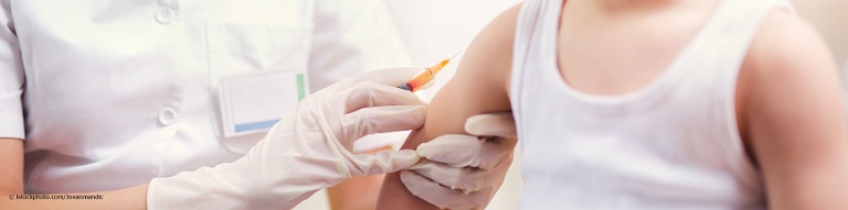 Ärztin spritzt Kind im Alter von fünf bis sechs Jahren eine Auffrischungsimpfung gegen Diphtherie.