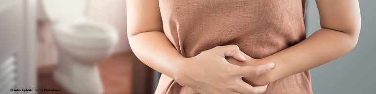 Frau mit Verstopfung hält sich den schmerzenden Bauch.