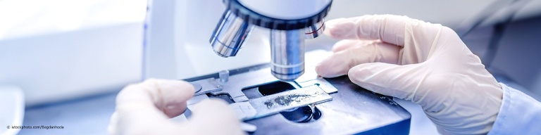 Bei docinsider registrierter Facharzt für Anatomie untersucht eine flüssige Probe unter dem Mikroskop.