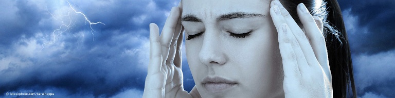 Frau mit Migräne steht unter einer Gewitterwolke und fasst sich an die Schläfen.