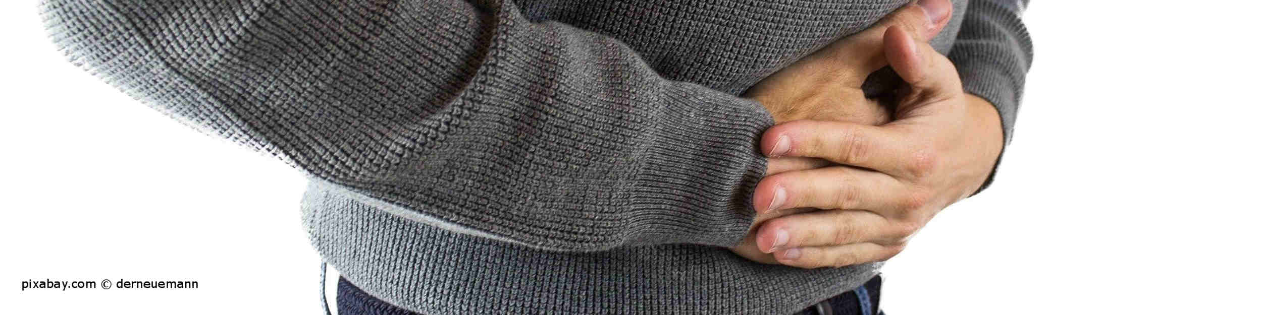 An Giardien leidender Mann hat Blähungen und Verdauungsbeschwerden und hält sich den Bauch.