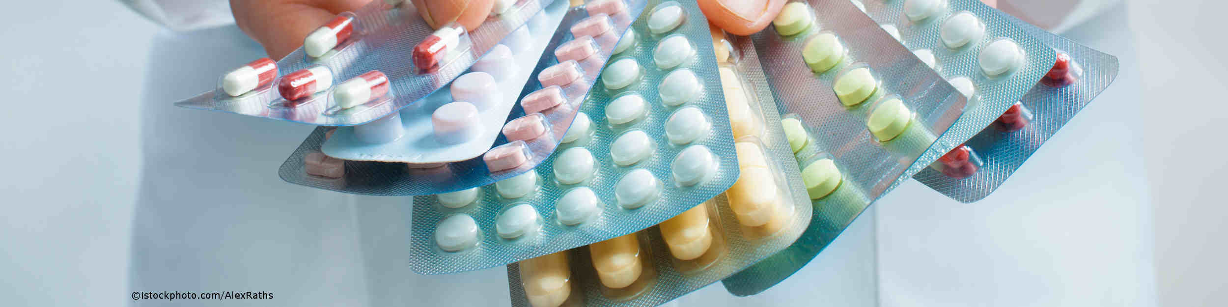 Arzt hält Tabletten in verschiedenen Größen in den Händen.